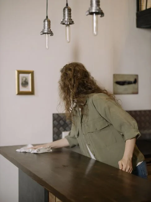 Un homme nettoie une fenêtre en verre avec une raclette, en noir et blanc, mettant en valeur un travail professionnel.
